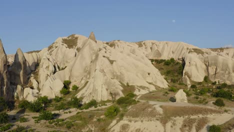 drone volando sobre campos de valle de tierras de cultivo verde entre formaciones rocosas cappadocia turquía