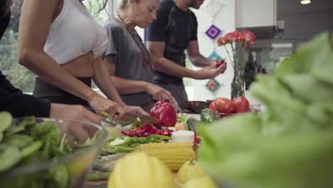 tiro cortado de personas cocinando verduras en la cocina
