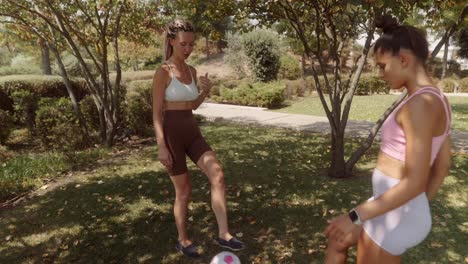 two women playing soccer in the park