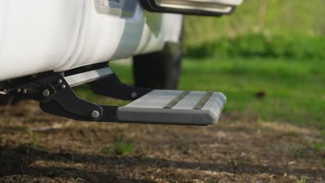 female stepping out on slippers via electric rv step, close up