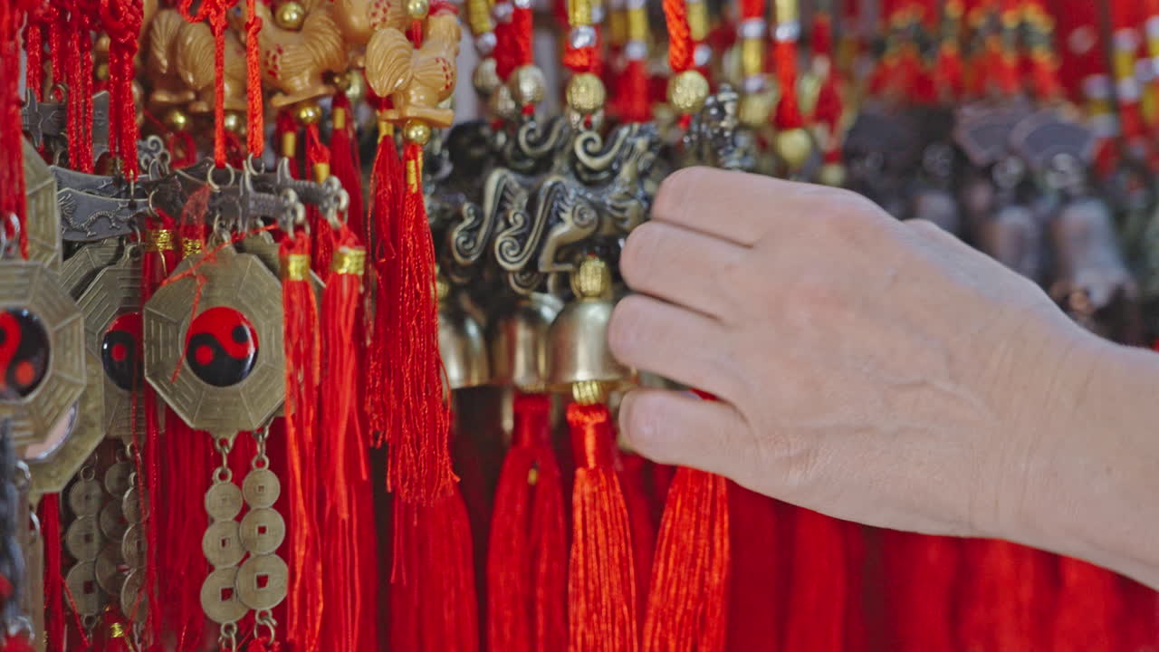 Mão Examinando Amuletos da Sorte Chineses Tradicionais