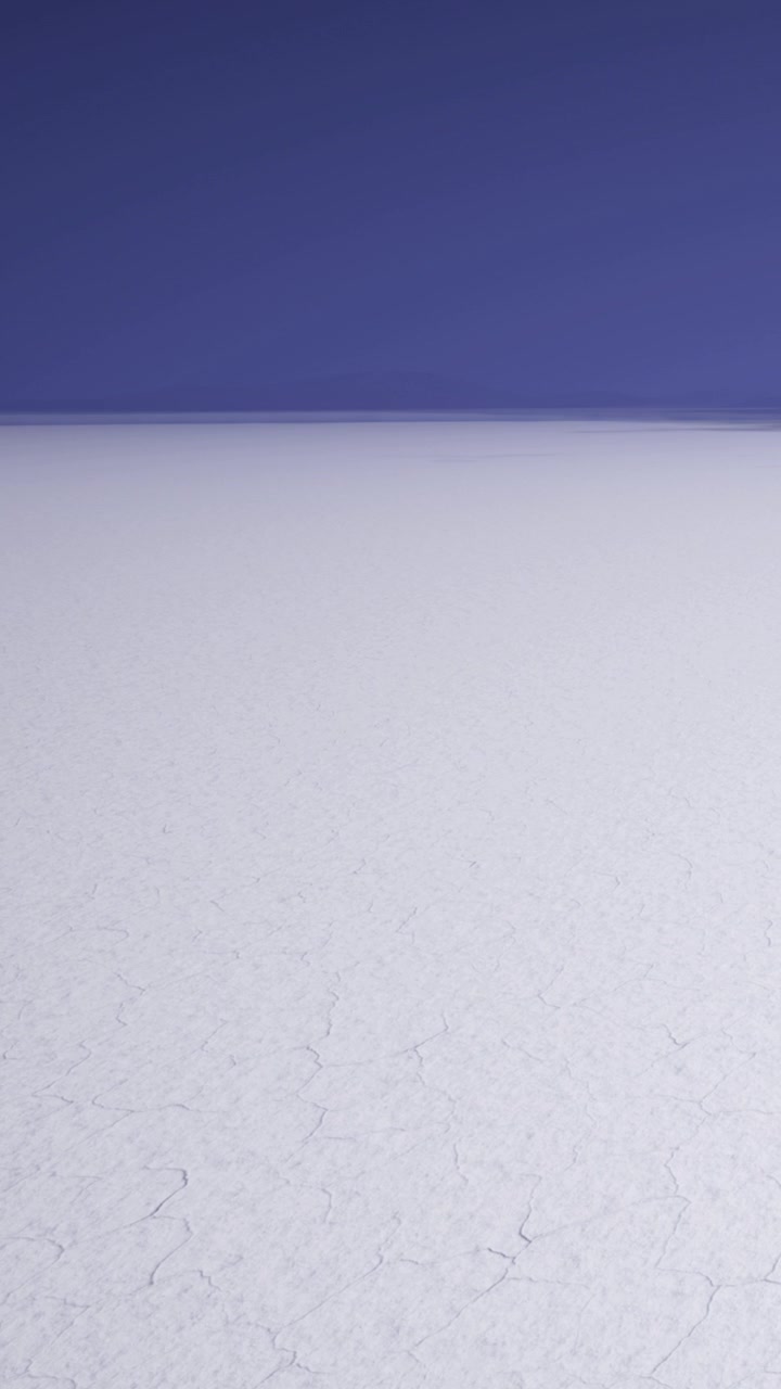 Flat salt desert stretches under a clear blue sky with distant horizon