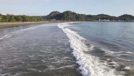 A-long-wave-crashing-ashore-at-the-empty-Quepos-beach-on-Damas-Island,-Costa-Rica