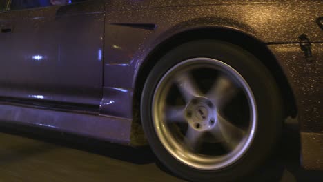 coche modificado púrpura conduciendo por la noche