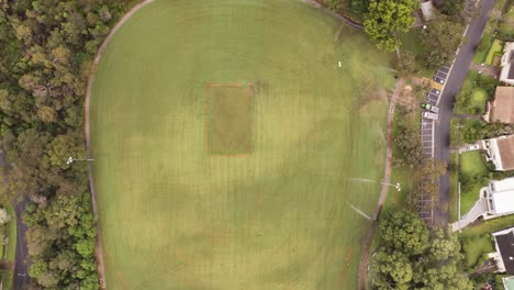 hyperlapse of sprinklers and tractor maintaining a playing field