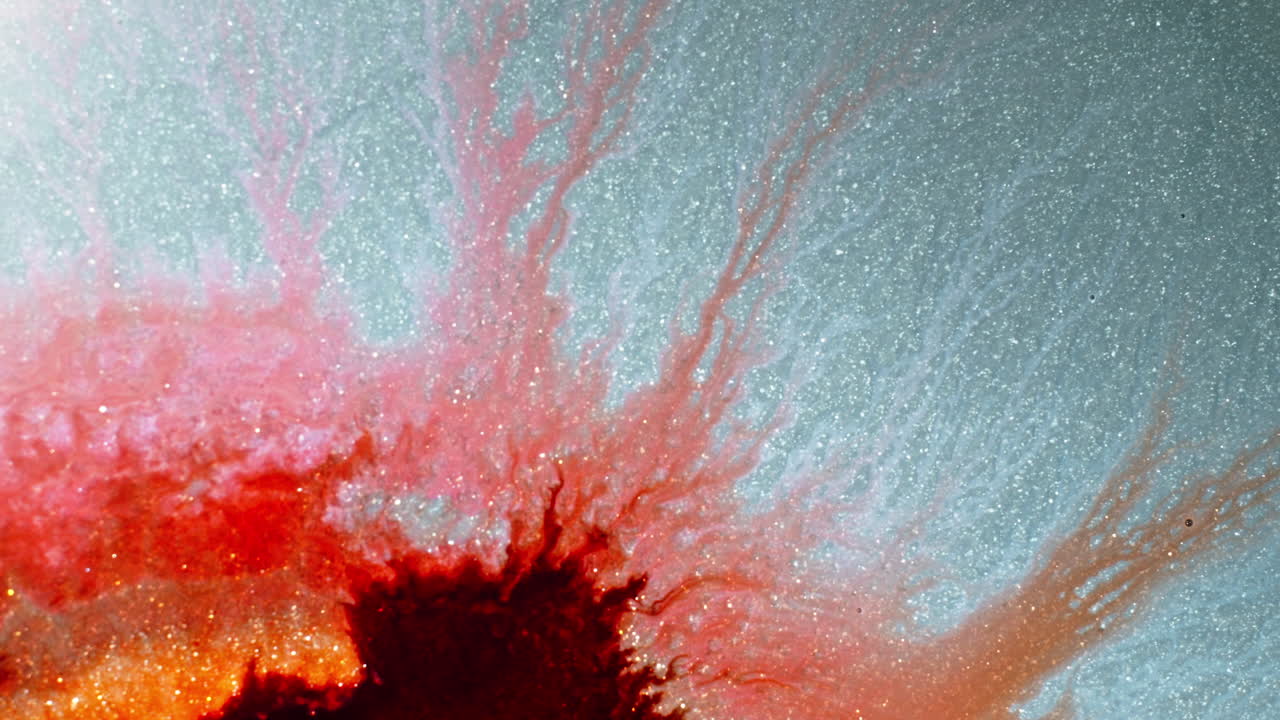 Colorful ink spreading in water, with macro shot capturing intricate patterns and textures