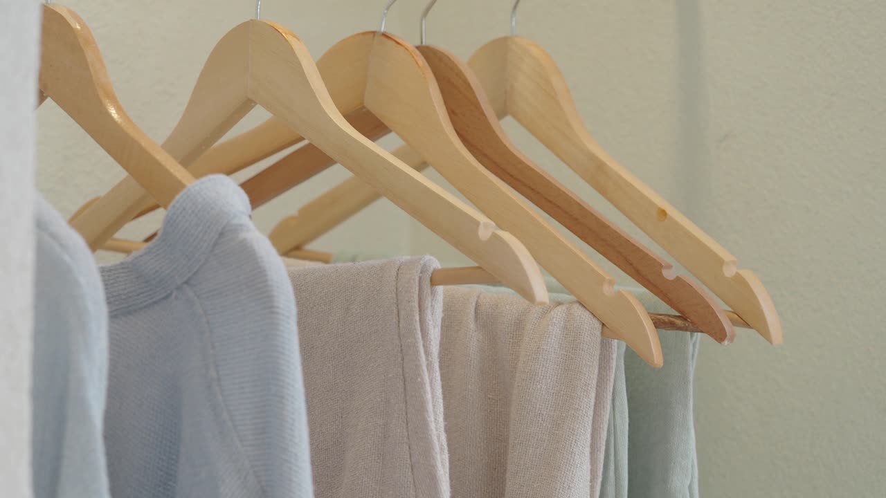 Pastel Clothes Hanging on Wooden Hangers