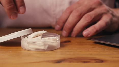 snus nicotine tobacco close up, pack of tobacco for gum. unhealthy addiction. man opening box with snus and taking one.