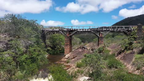 Eine-Alte-Verlassene-Brücke-überquert-Den-Fluss-In-Den-Kargen-Hügeln