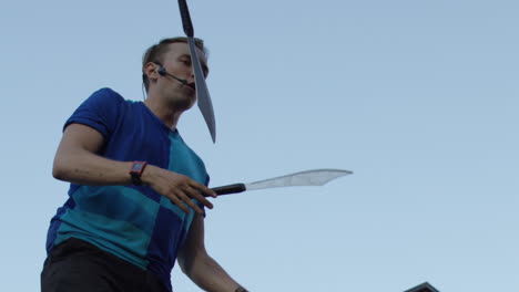 Slow-motion-juggler-with-swords-in-city-busker