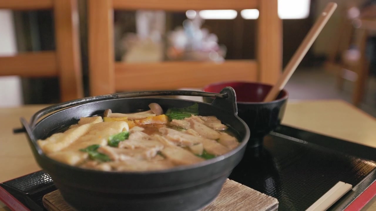 Una ciotola calda di Hōtō, un piatto tradizionale giapponese con noodles piatti, brodo di miso saporito, verdure, funghi e carne - Primo piano