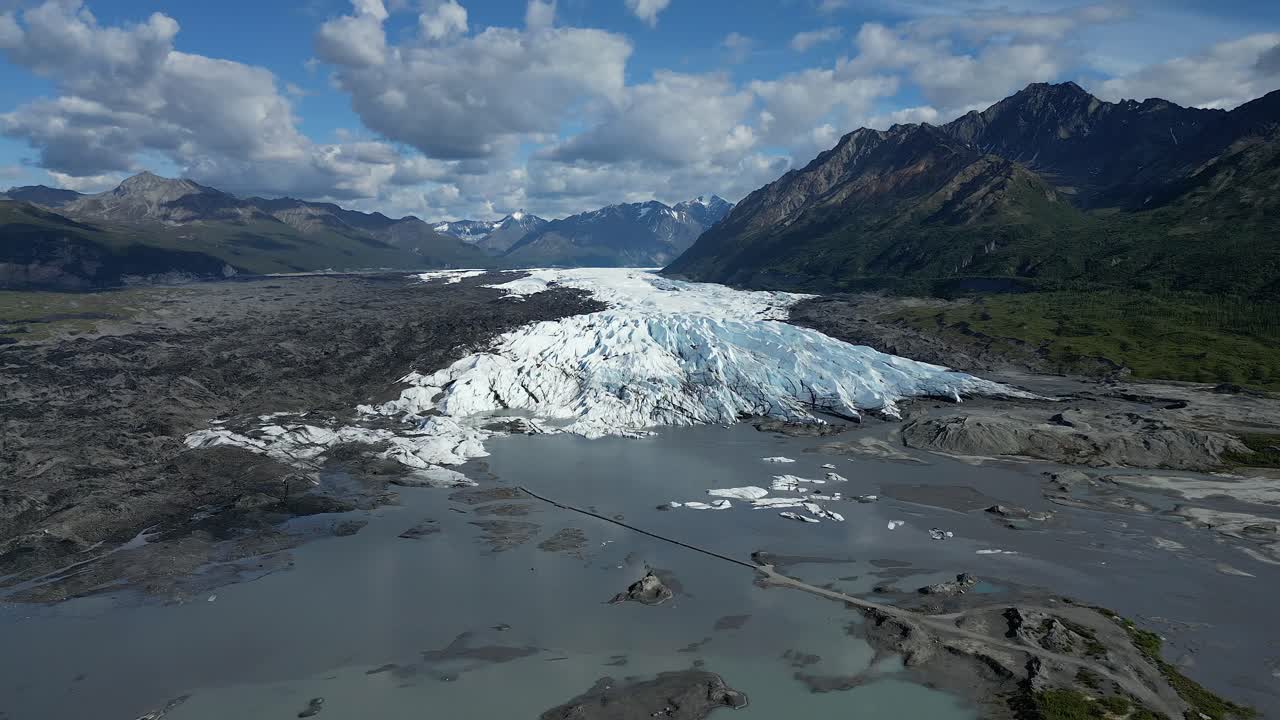 imágenes de drones acercándose a un glaciar desde el borde de un lago glacial