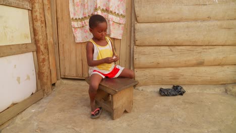 cute nice little black african children play alone in a cornet of wooden houses in remote village of africa