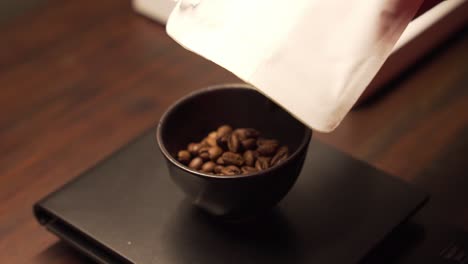 Gießen-Sie-Kaffeebohnen-In-Eine-Keramiktasse,-Um-Das-Genaue-Gewicht-Auf-Der-Elektronischen-Waage-Zu-Erhalten