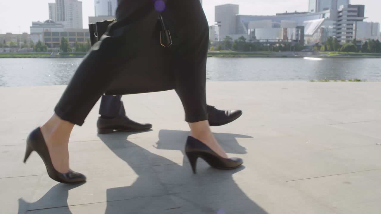 Business Couple Walking Along Embankment