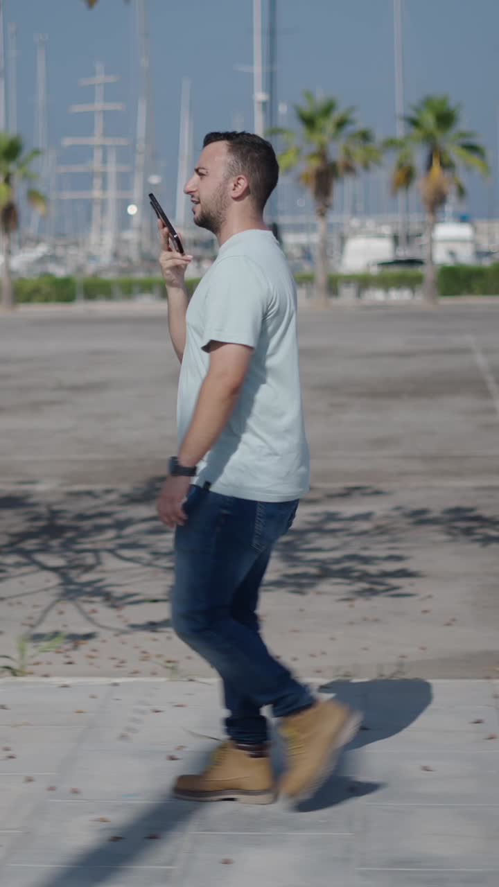 Man walking and talking on his phone in a marina