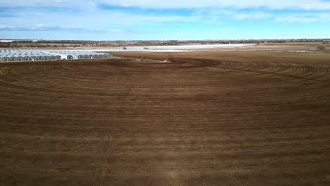 aerial view of empty plowed field near the greenhouse in countryside in colorado