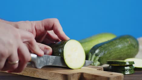 남자의 손은 칼로 익은 zucchini를 렀습니다.