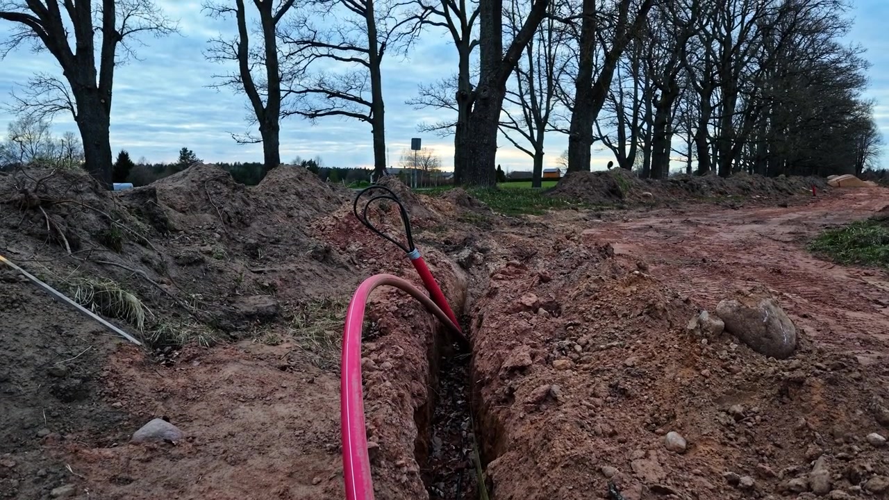 Laying underground electrical and fiber optic cables in a trench
