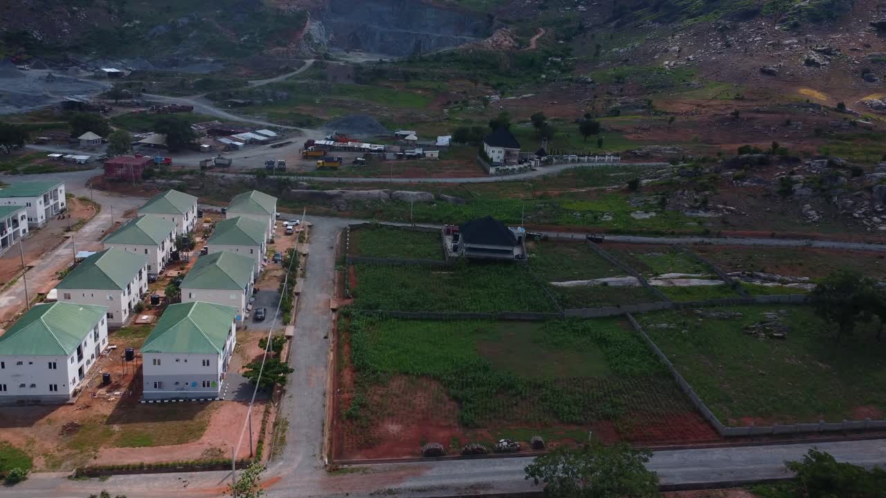Aerial perspective of red-roof housing units organized in blocks at residential site in Abuja, Nigeria. A newly built green roof estate in Africa