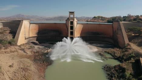aerial panoramic view arched dam wall with water discharging