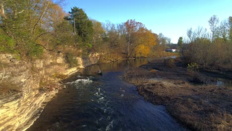 aerial flying backward while person in canoe traverses rapids