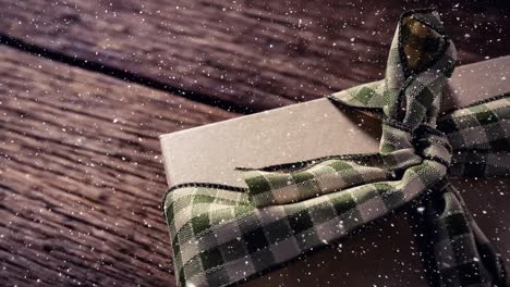 falling snow with christmas gift on wood