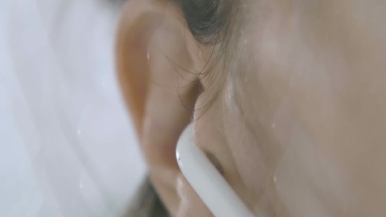 inserte la vaina de aire en el oído, detalle de cámara lenta y con lente de caleidoscopio, efecto caleidoscópico, mágico