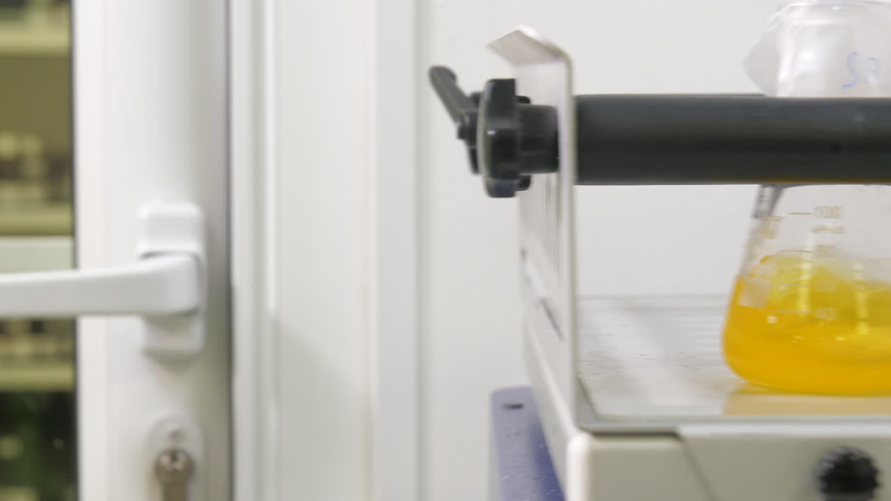 agitador orbital para mezclar, agitar, combinar muestras biológicas en frascos de vidrio: control deslizante de primer plano hacia la izquierda