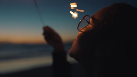 Porträt-Mädchen-Gemischter-Abstammung-Hält-Wunderkerze-Am-Strand-Bei-Sonnenuntergang-Und-Feiert-Silvester.-Junge-Frau-Genießt-Die-Feierlichkeiten-Zum-Unabhängigkeitstag-Am-4.-Juli