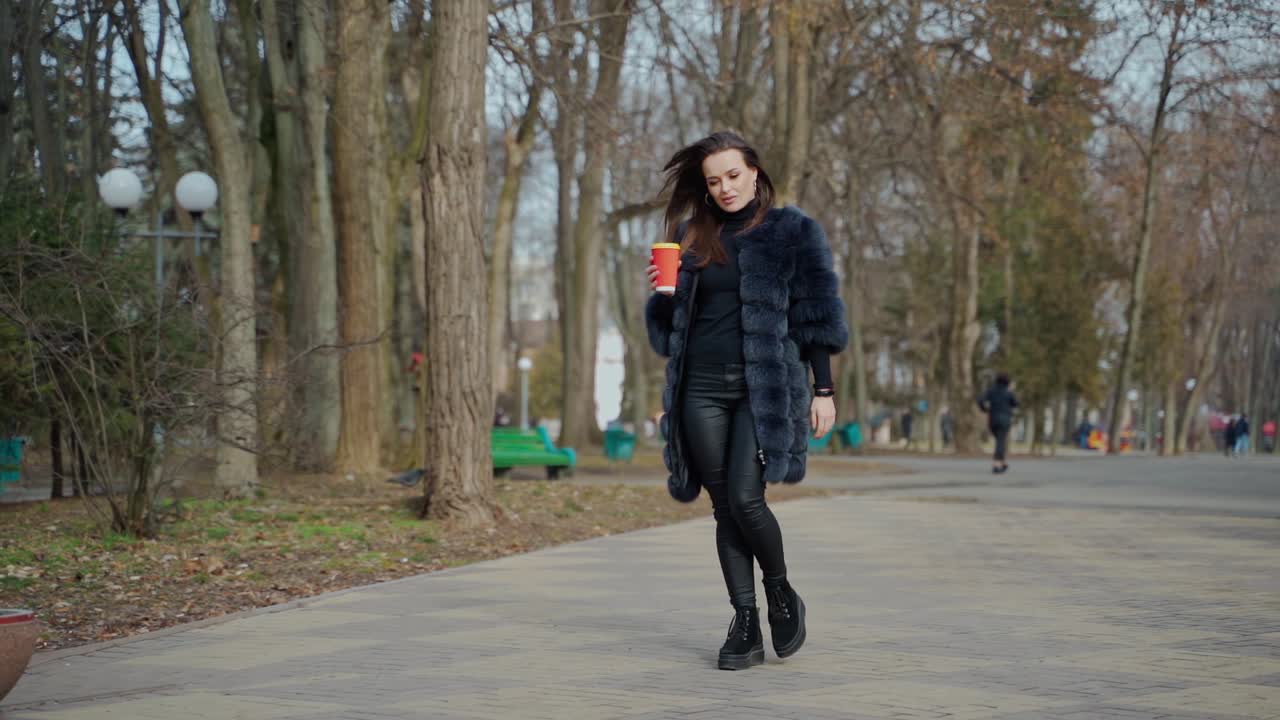 Fashion outdoor view of woman. Fashion portrait of pretty woman posing against amazing park background
