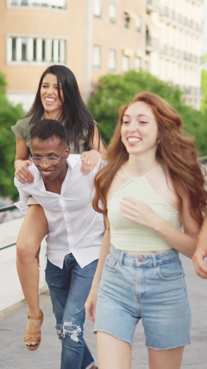 Joyful friends having fun outdoors with a piggyback ride