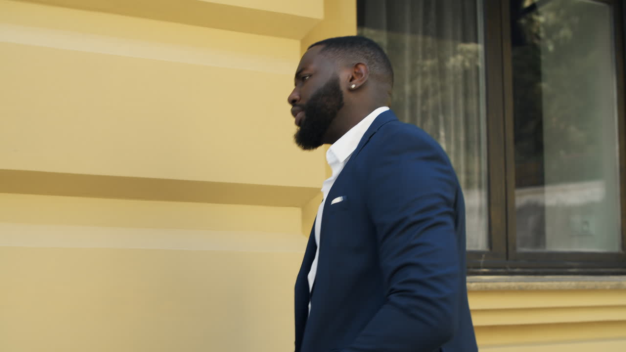 un exitoso hombre de negocios afro bailando en una calle urbana.