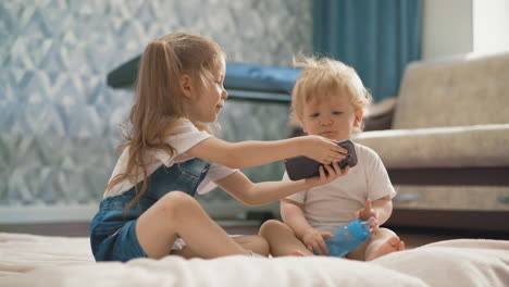 hermano y hermana, niños, sentados en el suelo