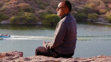 Hombre-Aislado-Sentado-En-La-Cima-De-La-Montaña-Con-Vista-Al-Lago-Desde-Un-ángulo-Plano-Se-Toma-Un-Video-En-El-Lago-Kaylana-Jodhpur-Rajasthan-India