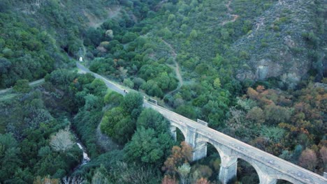 Aerial-tracks-cyclists-riding-toward-rail-trail-tunnel-from-old-bridge