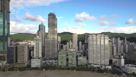 Aerial-view-looking-over-of-oceanfront-skyscrapers-of-Balneario-Camboriu-in-a-blue-sky-sunny-day---Santa-Catarina,-Brazil