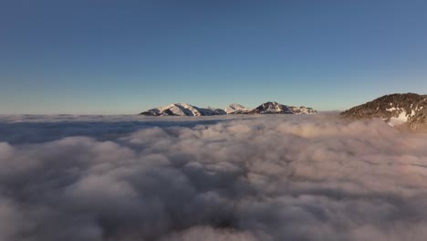 serene aerial view of rautispitz and glärnisch peaks, rising above dense sea of clouds in distance, glarus nord, switzerland.