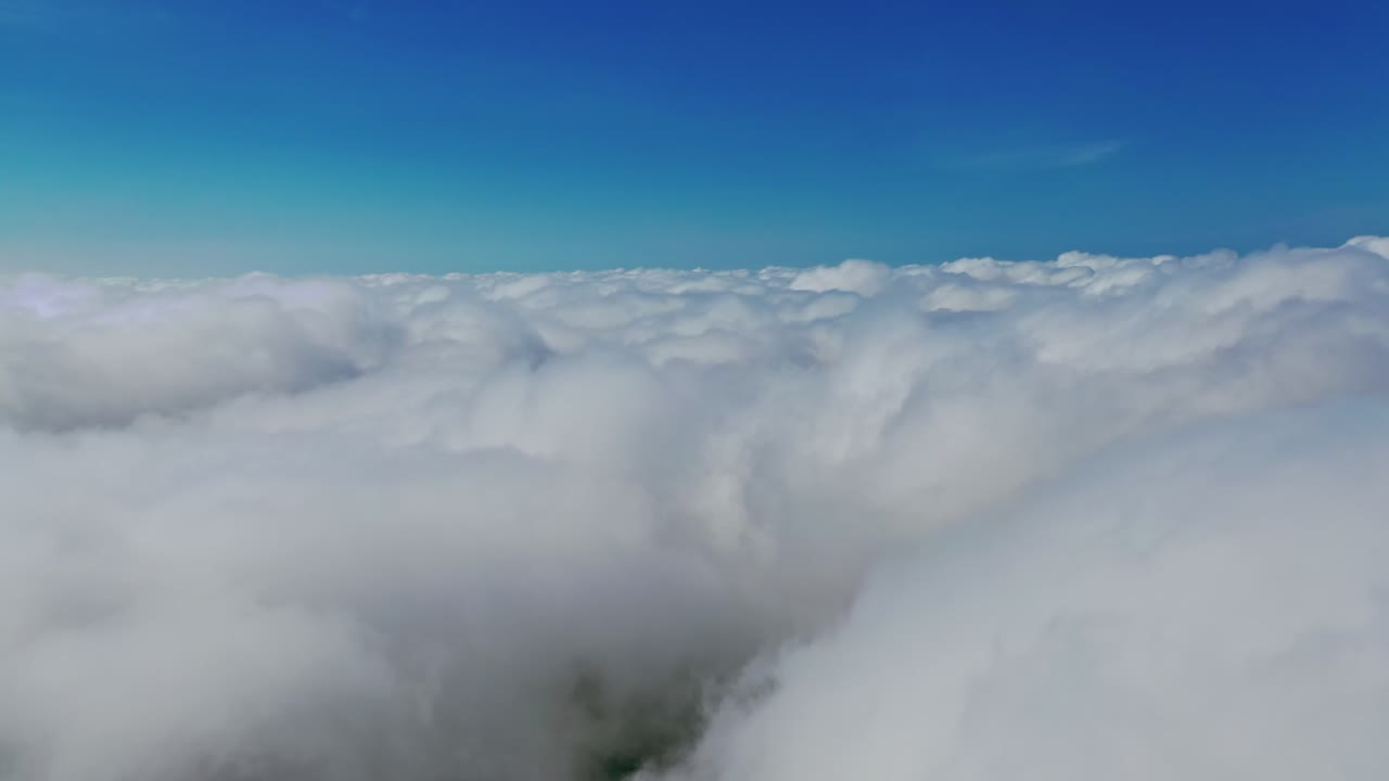 Soft clouds background. Amazing white clouds under clear blue sky. Travelling by cloudscape. View in the air.