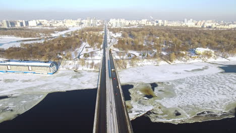 Panoramic-view-on-winter-city-from-drone-above.-Car-traffic-on-highway-bridge