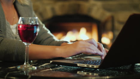 mujer trabajando en una laptop con vino