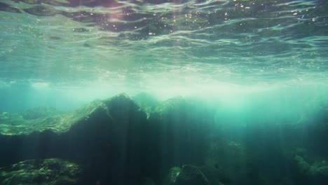 los rayos del sol brillan a través de la superficie del océano en el arrecife de coral hawaiano