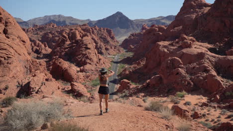 Female-Landscape-Photographer-Taking-Photos-of-Road-in-Valley-of-Fire-State-Park-Nevada-USA-From-Lookout-on-Hot-Sunny-Day,-Full-Frame