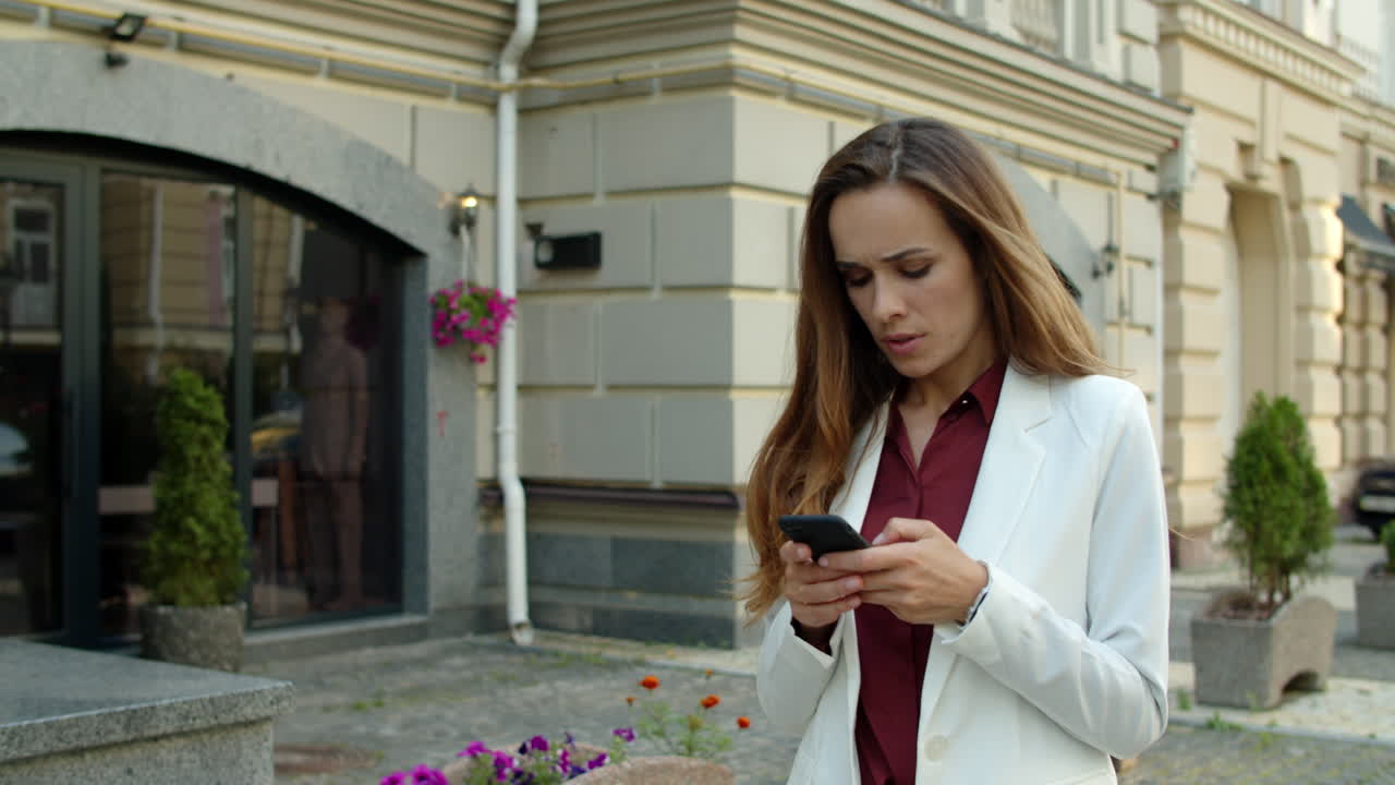 mujer de negocios enfocada escribiendo mensajes en el teléfono móvil al aire libre