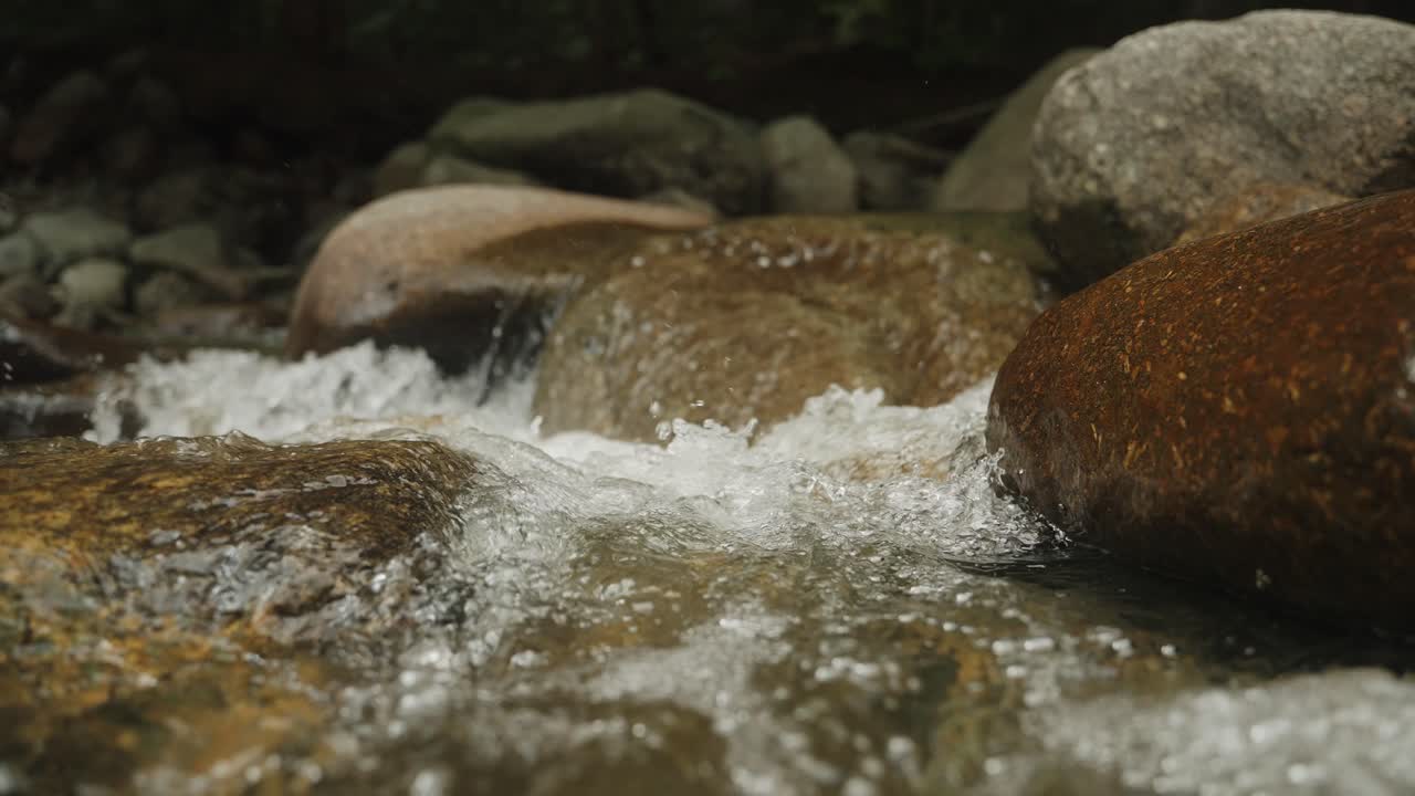 River water flowing through rocks shallow depth of field 120fps