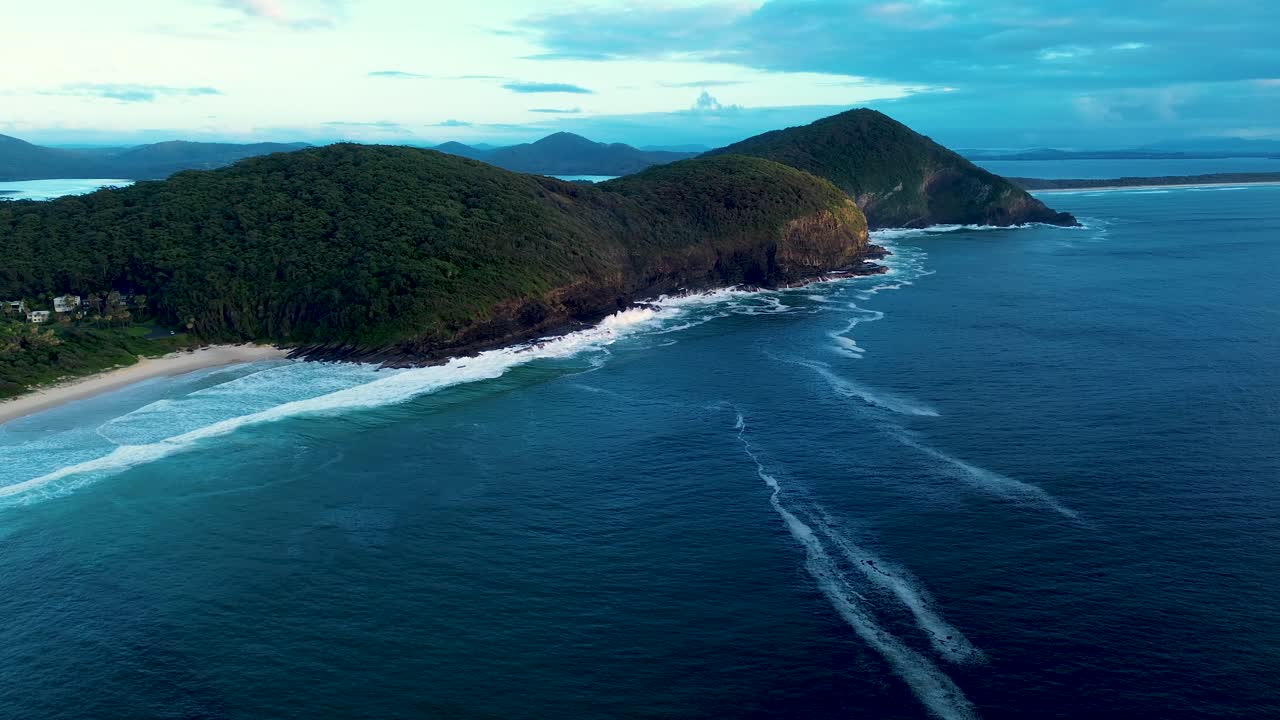 Drone aerial landscape of rugged bushland trees and mountain range in Booti Booti National Park headland coastline with ocean reef and sandy bay Elizabeth Beach Pacific Palms Forster travel holidays