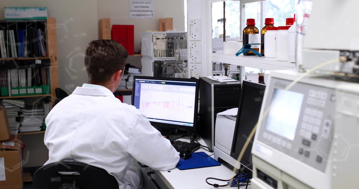 Animation of chemical formulas over back view of caucasian male lab worker using computer