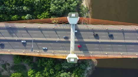 car moving on modern cable stayed bridge over sea in developed city aerial view