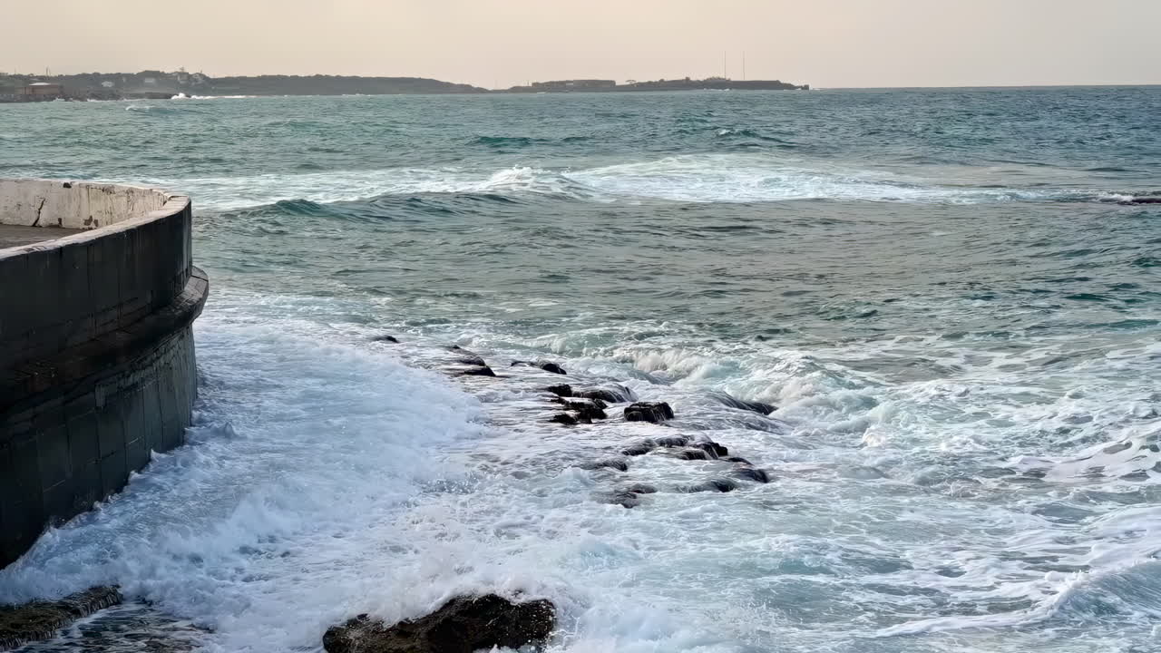 Water splashing over rocks on the shore in Kyrenia, Girne, Cyprus