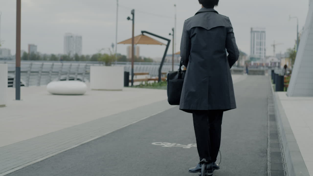 Businessperson using electric scooter in urban setting